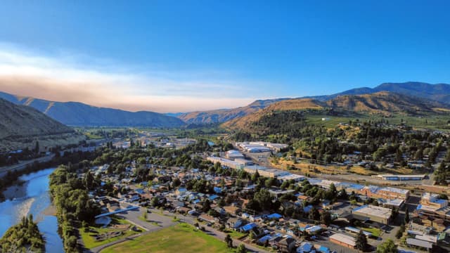Aerial view of a town in a valley with a river and mountains